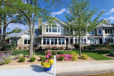 高級な巨大なトラディショナルスタイルのおしゃれな家の外観 (混合材サイディング、緑の外壁) の写真