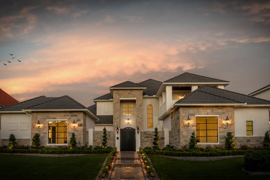 Large transitional beige two-story brick house exterior idea in Houston with a gambrel roof and a shingle roof