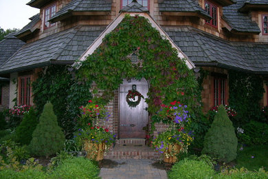 Cette image montre une grande façade de maison beige traditionnelle en stuc à un étage avec un toit à croupette.