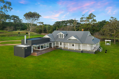 Idee per la villa bianca country a due piani di medie dimensioni con rivestimento in legno, tetto a mansarda e copertura in metallo o lamiera