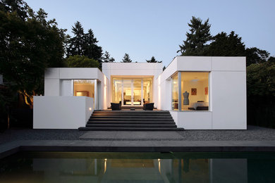 Inspiration för ett funkis vitt hus, med allt i ett plan och platt tak