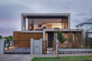 Imagen de fachada de casa marrón contemporánea de dos plantas con revestimientos combinados y tejado plano