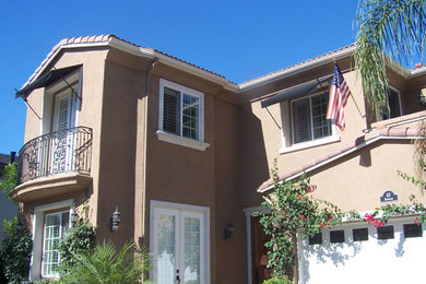 Small and beige mediterranean two floor render house exterior in Orange County.