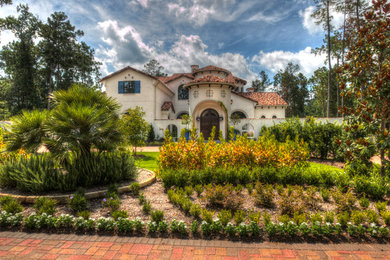 Inspiration for a huge mediterranean beige two-story stucco house exterior remodel in Houston with a tile roof