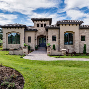 Huge mediterranean beige two-story mixed siding house exterior idea in Denver with a hip roof and a tile roof