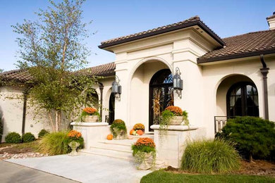Large mediterranean beige one-story stucco house exterior idea in Wichita with a shed roof and a tile roof