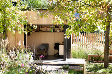 Esempio della facciata di una casa piccola contemporanea a un piano con rivestimento in legno e tetto piano