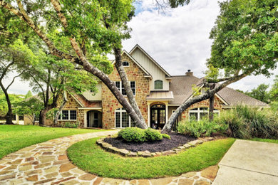 Mid-sized elegant beige two-story stone exterior home photo in Austin with a shingle roof