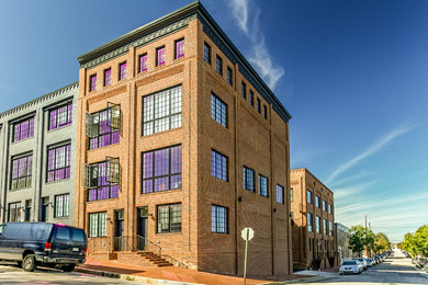 Foto della facciata di una casa industriale a tre piani con rivestimento in mattoni