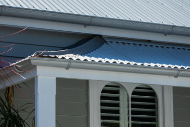 Modelo de fachada de casa gris tradicional pequeña de una planta con tejado de metal
