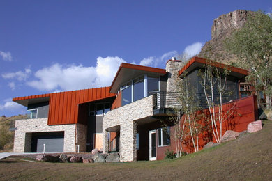 Modelo de fachada de casa multicolor contemporánea de dos plantas con revestimientos combinados, tejado plano y tejado de metal