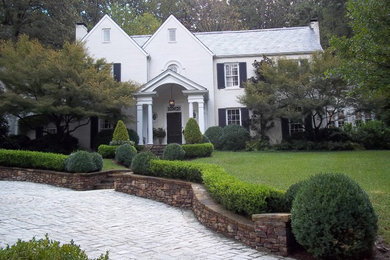 Large elegant white two-story stucco house exterior photo in Atlanta with a clipped gable roof and a shingle roof