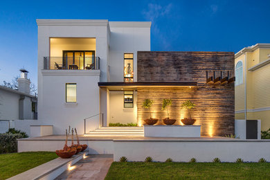 Imagen de fachada de casa blanca actual de tamaño medio de dos plantas con tejado plano y revestimientos combinados