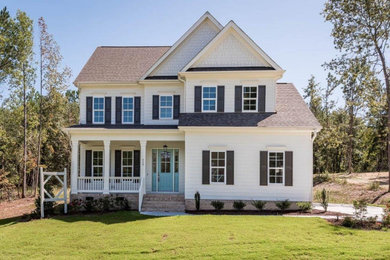 Mid-sized elegant white two-story house exterior photo in Raleigh