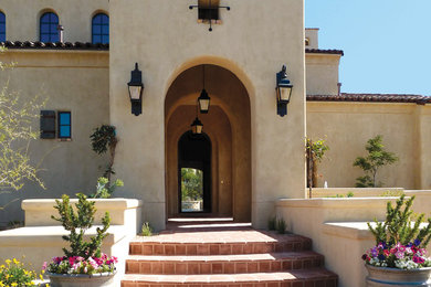 Example of a large tuscan beige two-story adobe exterior home design in Phoenix with a tile roof