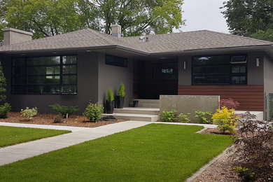 Modelo de fachada de casa gris retro de tamaño medio de una planta con revestimiento de hormigón, tejado a cuatro aguas y tejado de teja de madera