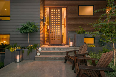 Foto de fachada gris de tamaño medio de dos plantas con revestimiento de madera y tejado a dos aguas