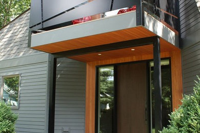 Modelo de fachada de casa verde retro extra grande de dos plantas con revestimiento de aglomerado de cemento y tejado de teja de madera