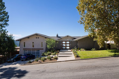 Example of a large 1960s gray two-story brick exterior home design in Los Angeles with a shingle roof and a gray roof