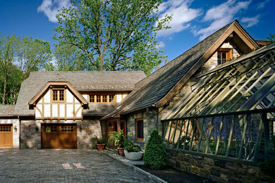 French country two-story stone exterior home photo in New York with a clipped gable roof