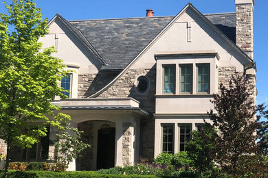 Foto de fachada de casa gris retro grande de dos plantas con revestimientos combinados y tejado de teja de madera