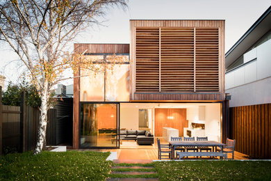 Esempio della facciata di una casa moderna a due piani di medie dimensioni con rivestimento in legno