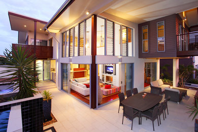 Réalisation d'une grande façade de maison design à un étage avec un revêtement mixte et un toit à deux pans.