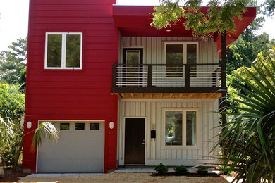 Foto de fachada roja moderna de tamaño medio de dos plantas con revestimientos combinados