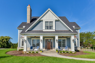 Imagen de fachada de casa azul y gris clásica renovada de tamaño medio de dos plantas con revestimiento de aglomerado de cemento, tejado a dos aguas, tejado de teja de madera y tablilla