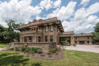 Large traditional brown three-story brick exterior home idea in Austin