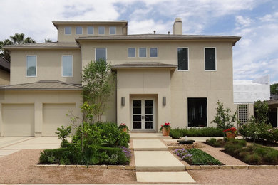 Example of a mid-sized classic beige two-story concrete gable roof design in Houston