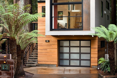 На фото: маленький, двухэтажный, деревянный дом в стиле модернизм с плоской крышей для на участке и в саду