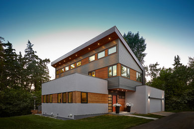 Inspiration for a large contemporary white two-story mixed siding house exterior remodel in Edmonton with a shed roof
