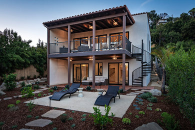 Large trendy beige two-story stucco exterior home photo in Santa Barbara with a tile roof