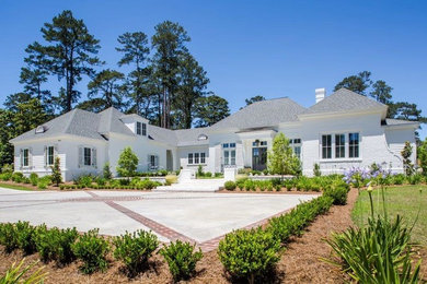 Example of a huge classic white one-story brick house exterior design in Atlanta with a shingle roof