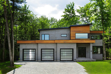 Example of a trendy black two-story brick flat roof design in Other