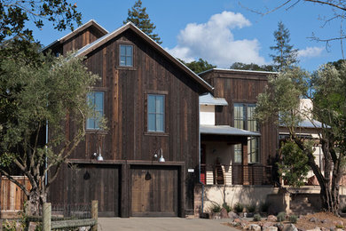 Foto de fachada de casa marrón rural de tamaño medio de dos plantas con revestimiento de madera, tejado de un solo tendido y tejado de metal