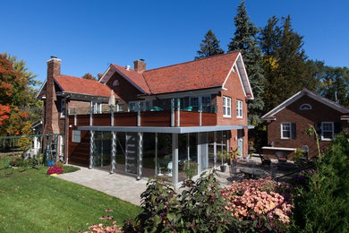Diseño de fachada de casa roja contemporánea de dos plantas con revestimientos combinados y tejado de teja de madera