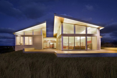 Ejemplo de fachada de casa gris moderna de dos plantas con revestimiento de metal y tejado de un solo tendido