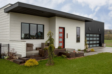 Photo of a medium sized and white modern two floor detached house in Milwaukee with mixed cladding.