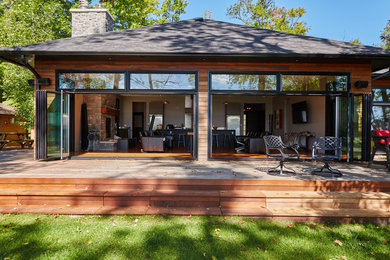 Medium sized and brown contemporary bungalow detached house in Toronto with wood cladding, a hip roof and a shingle roof.