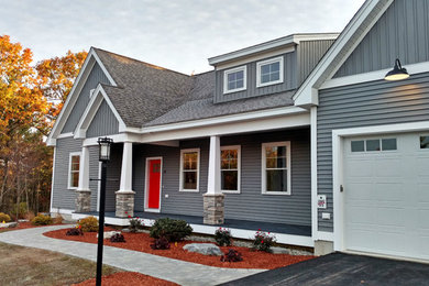 Inspiration for a mid-sized modern gray two-story vinyl exterior home remodel in Manchester with a shingle roof
