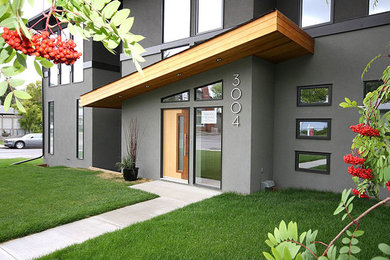 Mid-sized trendy gray two-story stucco exterior home photo in Calgary