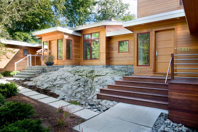Example of a large minimalist brown two-story wood house exterior design in Boston with a hip roof and a metal roof