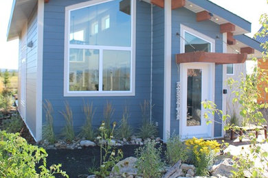 Ejemplo de fachada de casa azul romántica pequeña con revestimiento de madera y tejado de un solo tendido