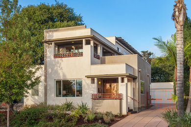 Trendy beige two-story stucco flat roof photo in San Diego