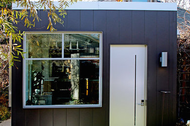 Modelo de fachada negra minimalista de tamaño medio de una planta con revestimiento de aglomerado de cemento y tejado plano