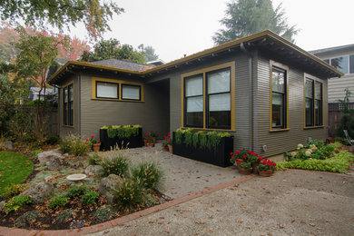 Cette image montre une petite façade de maison grise nordique de plain-pied avec un revêtement en vinyle, un toit à deux pans et un toit en shingle.
