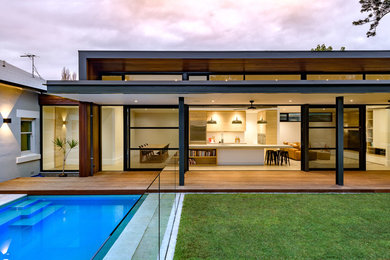 На фото: одноэтажный, деревянный, серый частный загородный дом среднего размера в стиле модернизм с металлической крышей