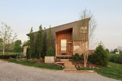 Idée de décoration pour une façade de maison marron design en bois à un étage avec un toit en appentis.